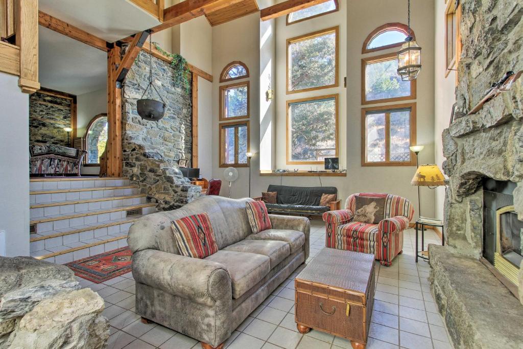 a living room with a couch and a stone fireplace at Historic Helena Retreat - Near Dtwn and Mt Helena! in Helena