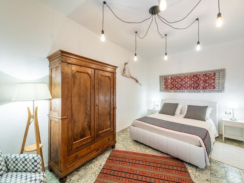 a bedroom with a bed and a wooden cabinet at CIVICO 11 in SantʼAntìoco