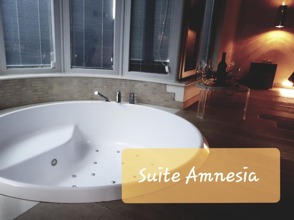 a bath tub in a bathroom with a sign that reads suite amnesia at Suite Amnesia in Mesagne