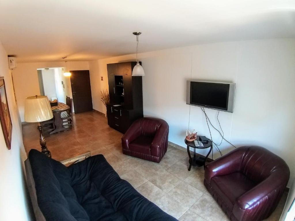 a living room with leather furniture and a flat screen tv at APART-CENTER VIP JUJUY in San Salvador de Jujuy