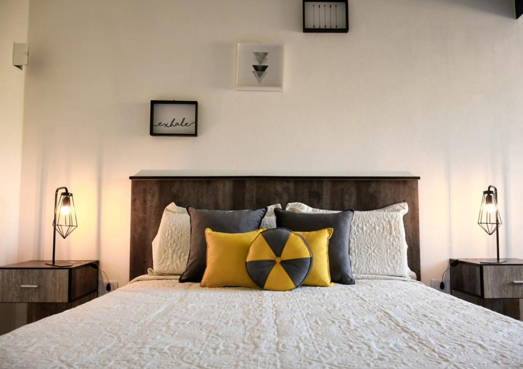 una camera da letto con un grande letto con cuscini gialli di Aluleta Suites a La Bolsa