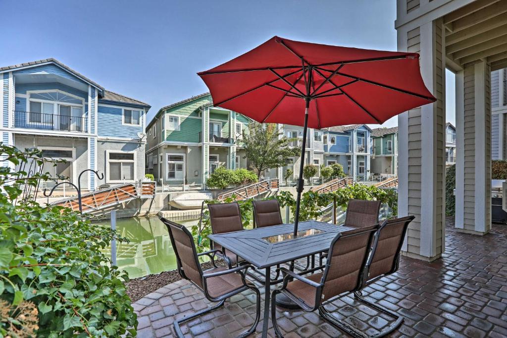 um pátio com uma mesa com um guarda-chuva vermelho em Waterfront Nevada Home with Balcony and Private Dock! em Sparks