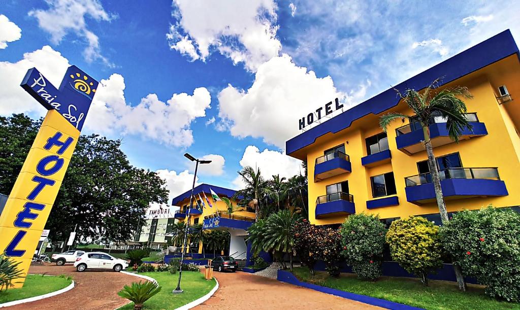 een geel gebouw met een bord ervoor bij Praia Sol Hotel in Santa Terezinha de Itaipu