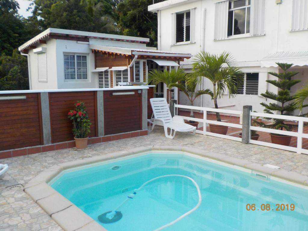 a swimming pool in front of a house at PETIT STUDIO DE CHARME TOUT CONFORT in Trois-Rivières