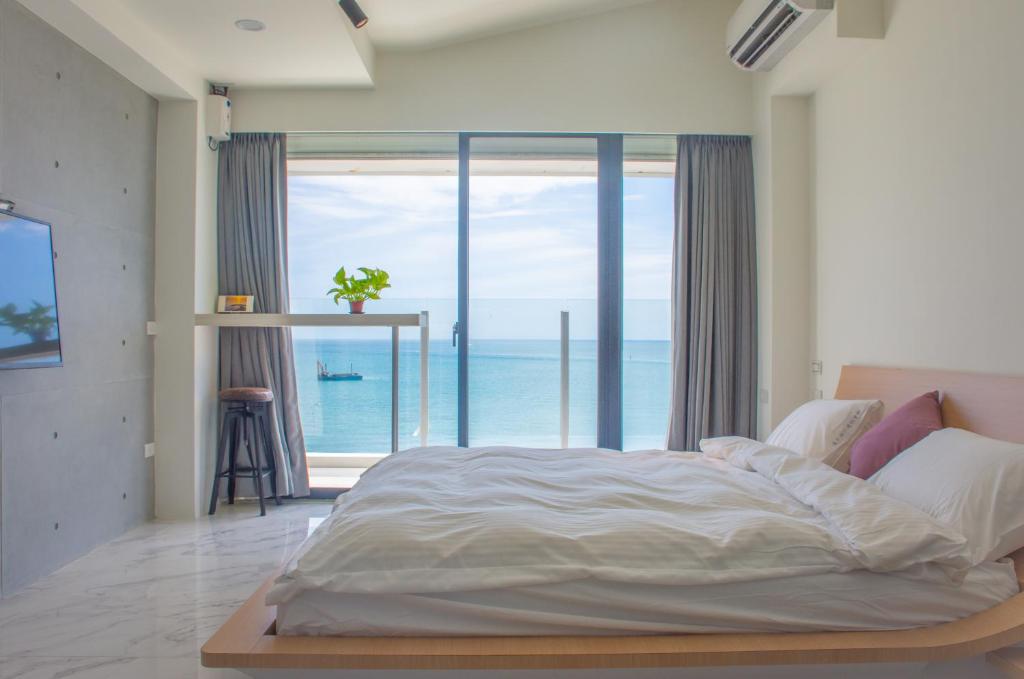 a bedroom with a large bed with a view of the ocean at BEACH FRONT VILLA in Baisha