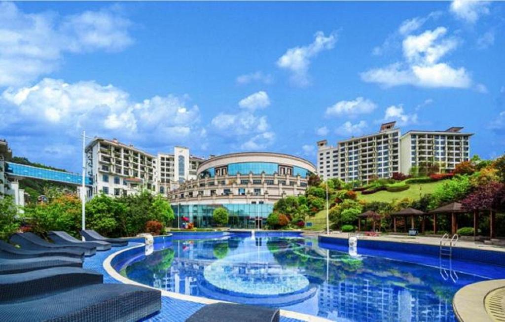 uma grande piscina em frente a um edifício em Country Garden Phenix Hotel em Zhangjiajie