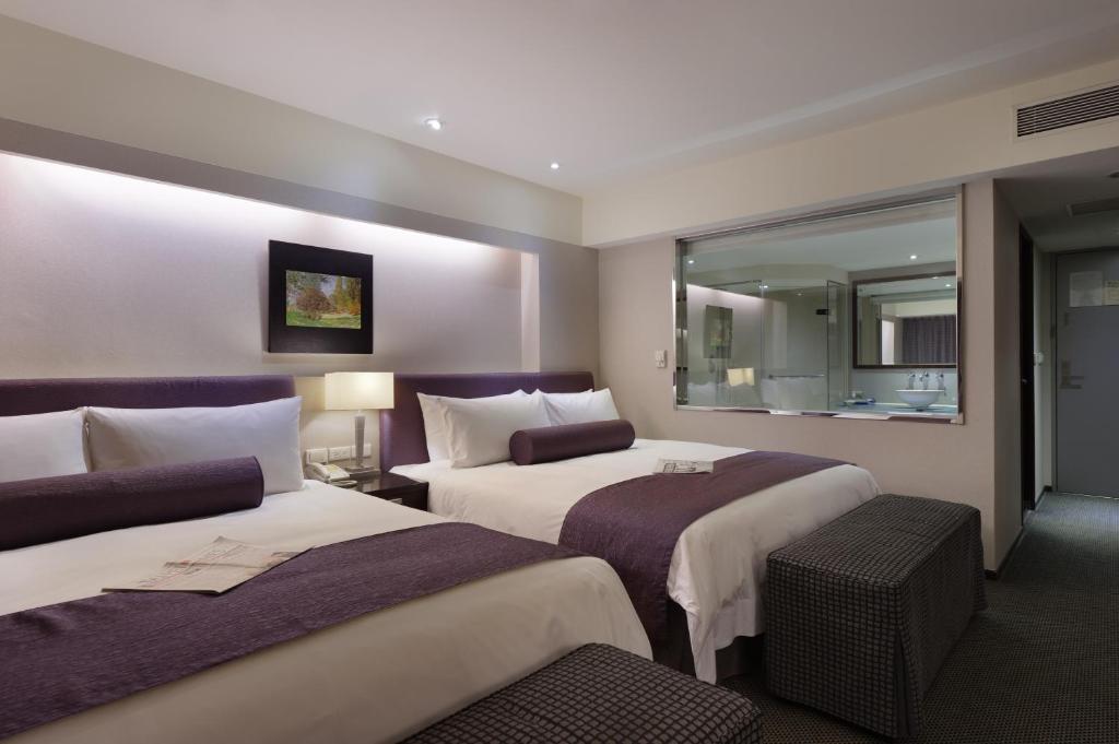 Habitación de hotel con 2 camas y espejo en K Hotel - Yunghe, en Yonghe