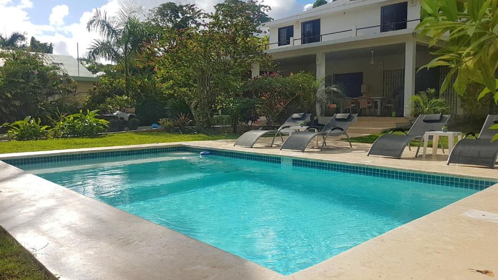 una piscina con sillas y una casa en La Belle Créole, en Las Galeras