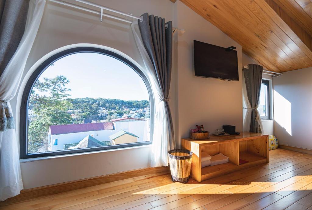 ein Bogenfenster in einem Zimmer mit Holzboden in der Unterkunft N'Queen Villa in Da Lat