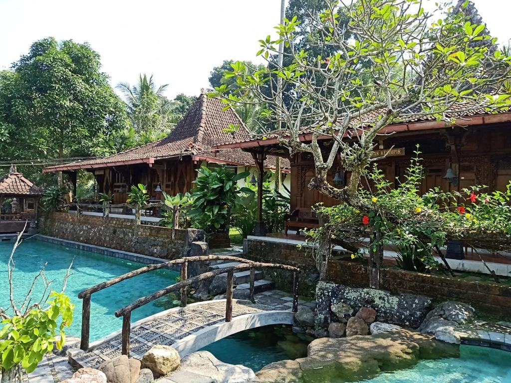 Jogloplawang Villa&Resort في كاليورانغ: منتجع فيه مسبح ومنزل