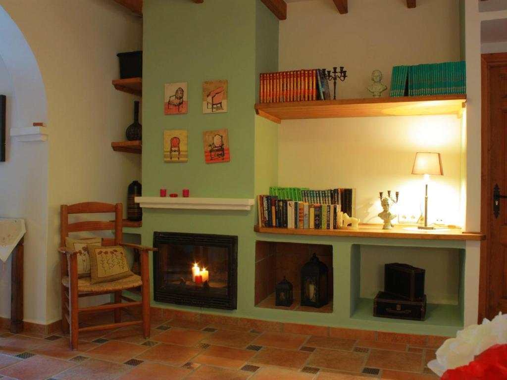 - un salon avec une cheminée et une chaise dans l'établissement Belvilla by OYO La F brica de Juan, à La Joya