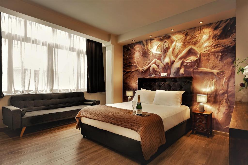 een hotelkamer met een bed en een bank bij Pallada Athens boutique rooms & apartments in Athene