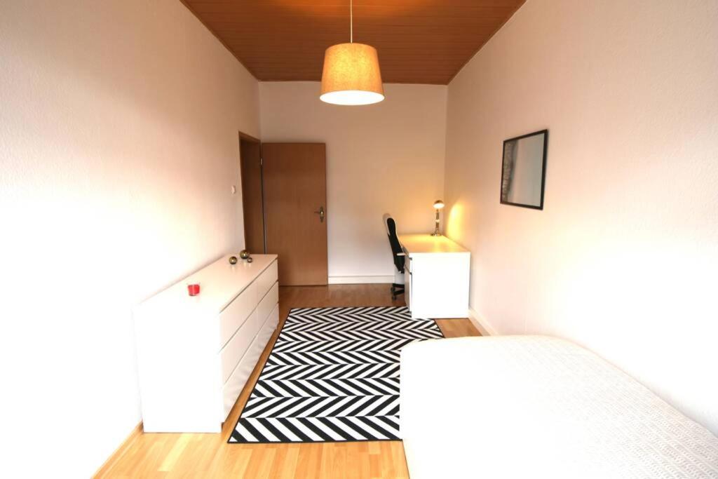 1 dormitorio con cama, escritorio y mesa en Charmante Wohnung ruhig und zentral gelegen, en Mannheim