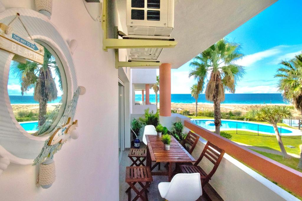 a balcony with a table and a view of the ocean at Apartasuites Royal Zahara, Máximo confort con vistas al mar in Zahara de los Atunes