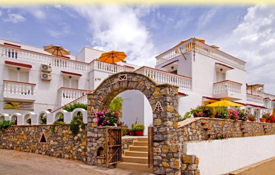 a building with a stone wall and an arch at Seva' s Studios in Livadia