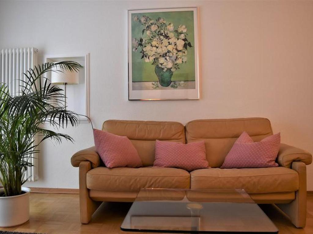 sala de estar con sofá marrón con almohadas rosas en Ferienwohnung Sonja, en Freiburg im Breisgau