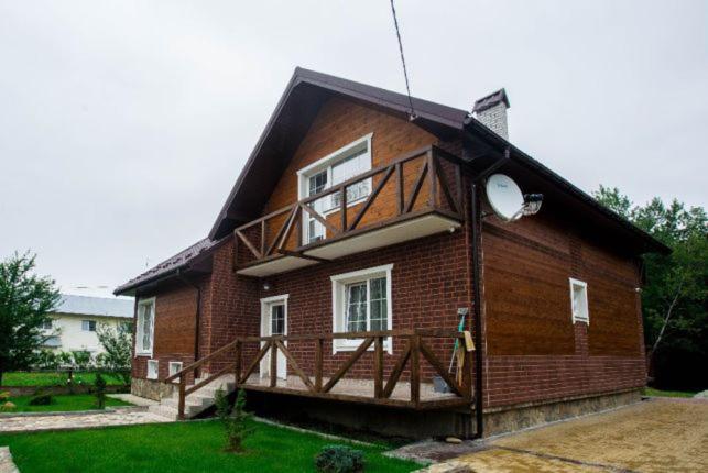 ein kleines Backsteinhaus mit Balkon darauf in der Unterkunft Садиба Вікторія in Morschyn
