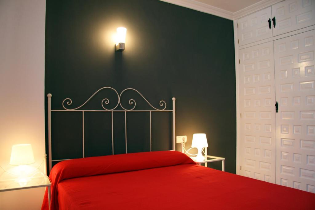1 dormitorio con cama roja y pared verde en First Line Beach Apartment with Two Bedrooms and Sea View, en Nerja