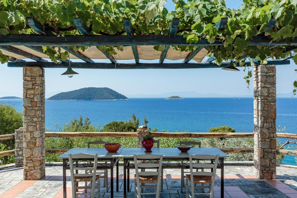 a table with chairs and a view of the ocean at Stamatiou Estate in Neo Klima