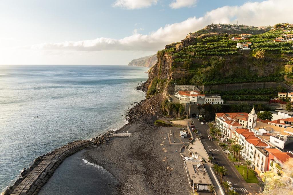 ポンタ・ド・ソルにあるVilla Ponta do Sol Apartmentの海のそばの崖の上の町の空中