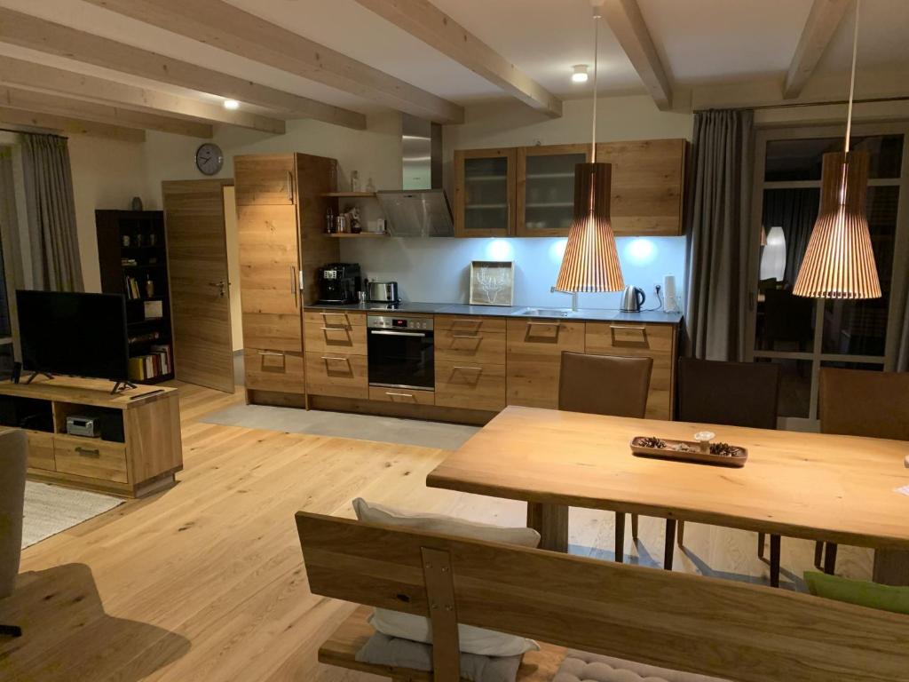 ein Wohnzimmer mit einem Tisch und einer Küche in der Unterkunft Bergmannstrost 5 Sterne Ferienwohnung in Sankt Andreasberg