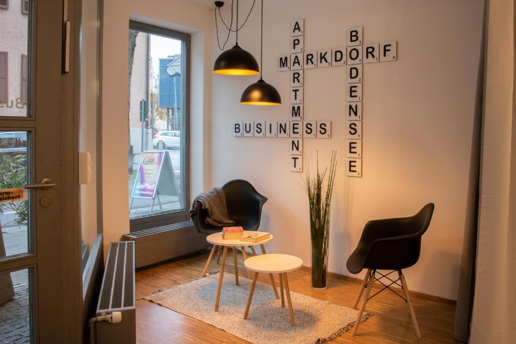 une chambre avec deux chaises, une table et un panneau dans l'établissement Business Apartment, à Markdorf