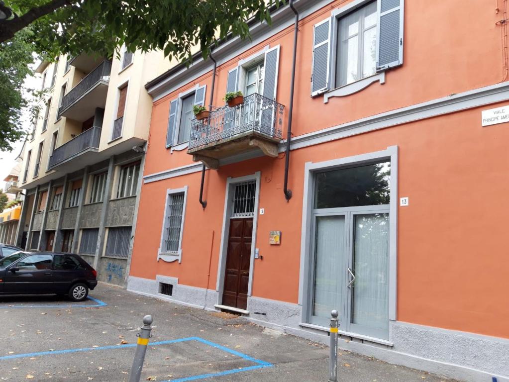 pomarańczowy budynek z balkonem przy ulicy w obiekcie ATELIER w mieście Voghera