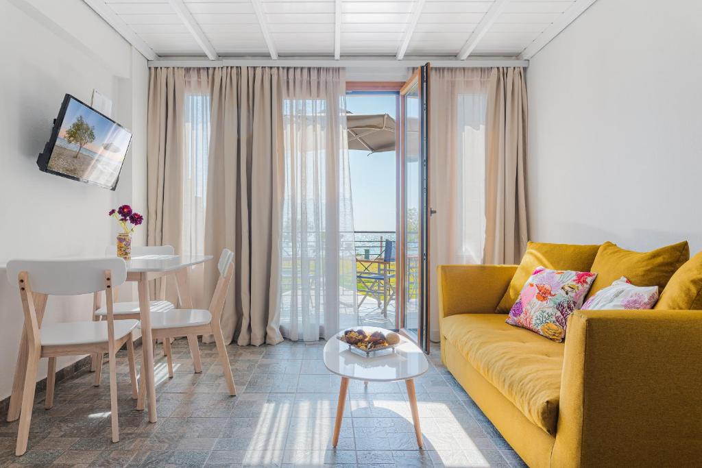 a living room with a yellow couch and a table at Naftilos Residences II in Potokáki