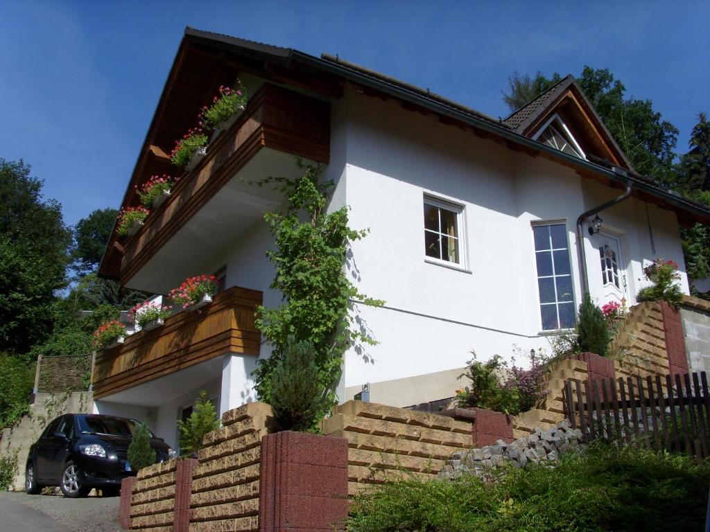 uma casa branca com caixas de flores e uma varanda em Ferienwohnung Schaub em Schmalkalden