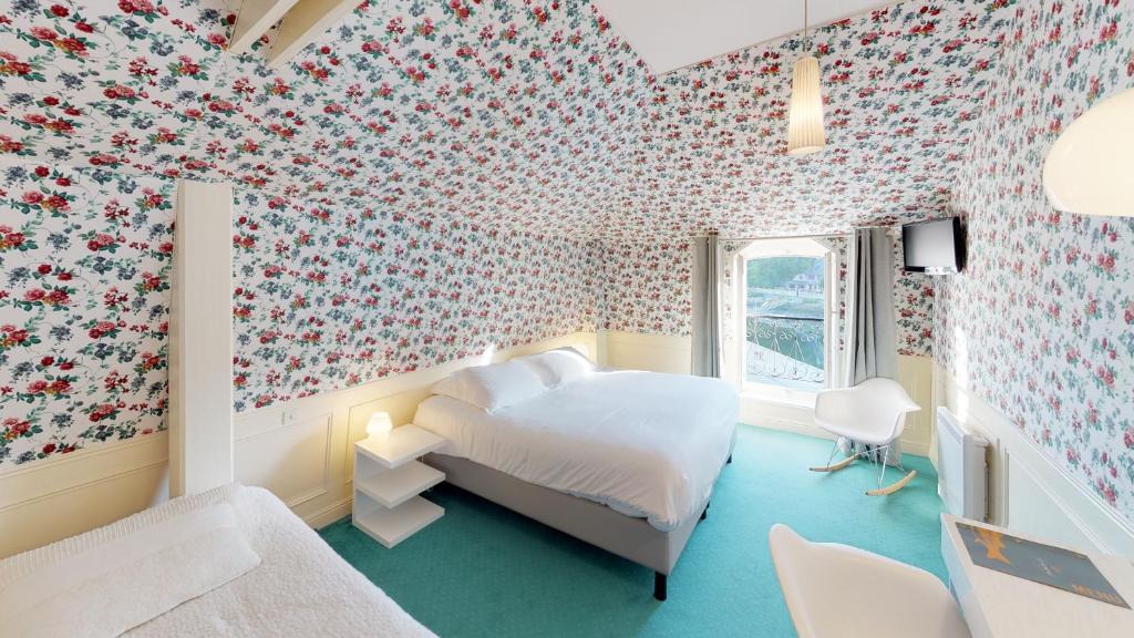 - une chambre avec un lit et du papier peint floral dans l'établissement Hotel de charme Les Mimosas, à Pont-Aven