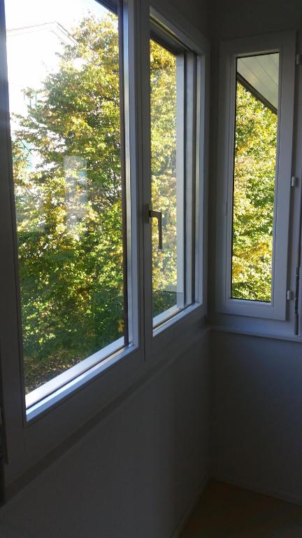 two windows in a room looking out at a tree at Gästezimmer in Zurich