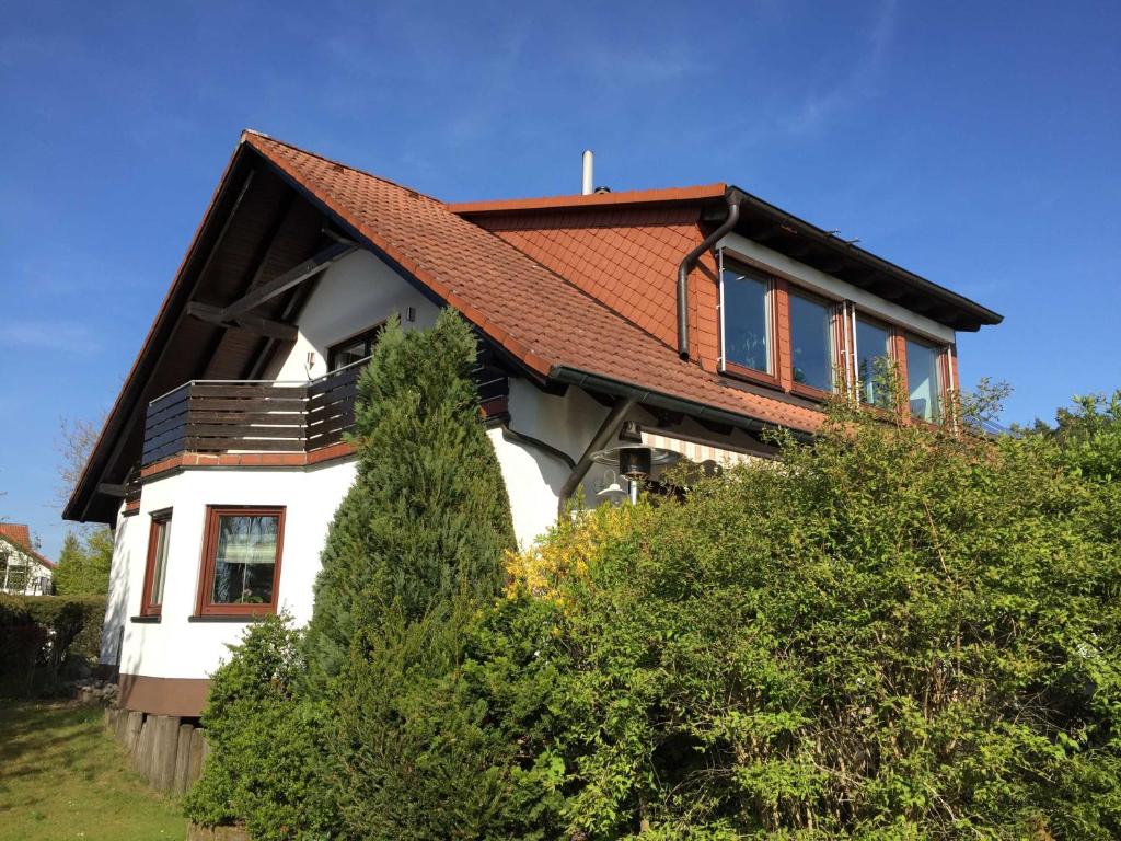 a house with a red roof on top of some bushes at Ferienwohnung Buchbergblick in Coburg