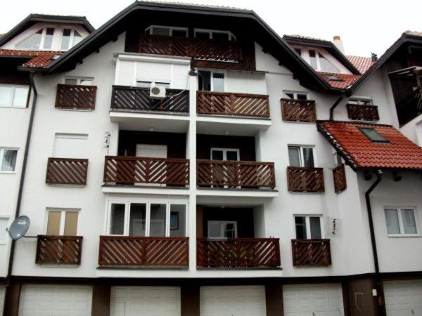 a white building with balconies on the side of it at Apartman Zlatibor Dimitrije in Zlatibor