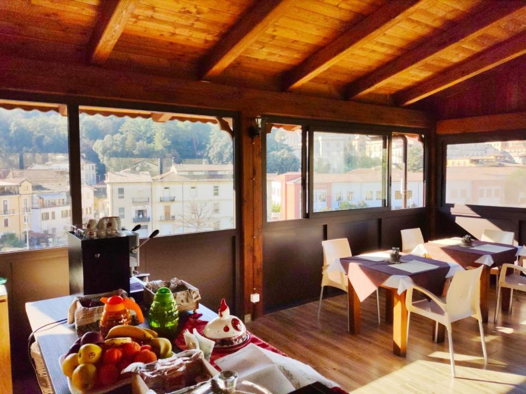 un comedor con mesas, sillas y ventanas en B&B L’antico Rudere, en Cosenza