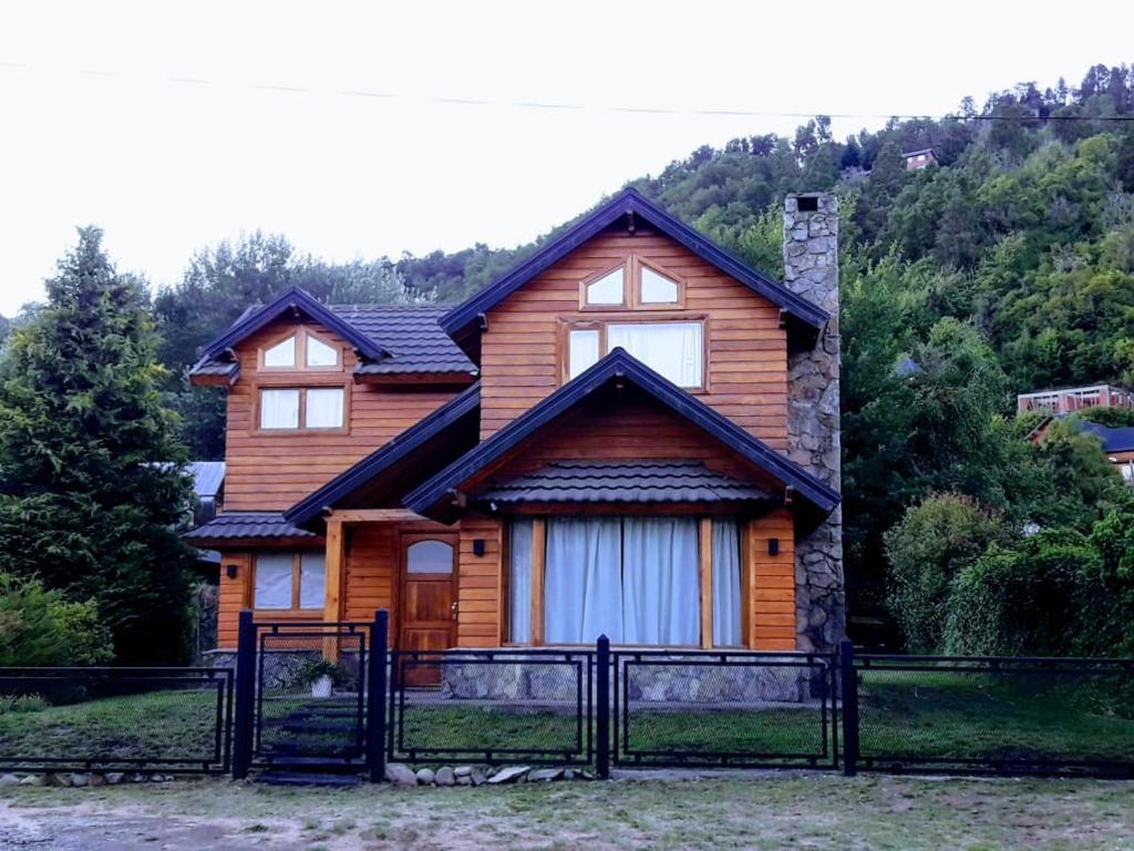 una casa de madera con una puerta delante en Cabaña Wefko - San Martin de los Andes, en San Martín de los Andes