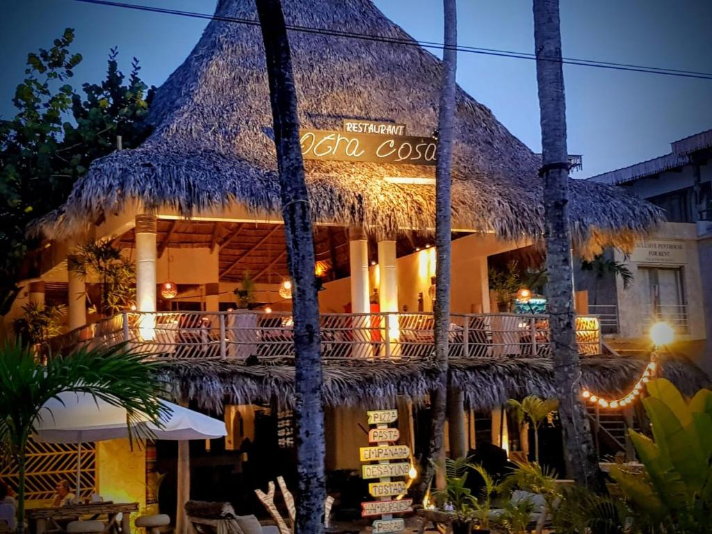 un complejo con un edificio con techo de paja y un restaurante en Afreeka Beach Hotel, en Las Terrenas
