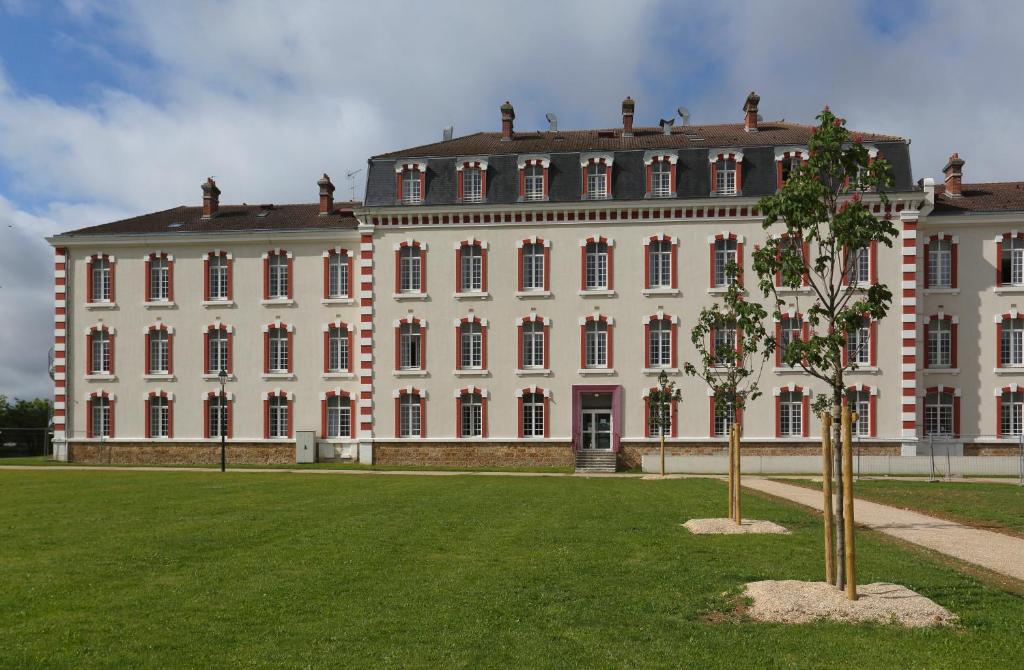 duży biały budynek z drzewem przed nim w obiekcie Vacancéole - Les Demeures Champenoises Confort w Épernay