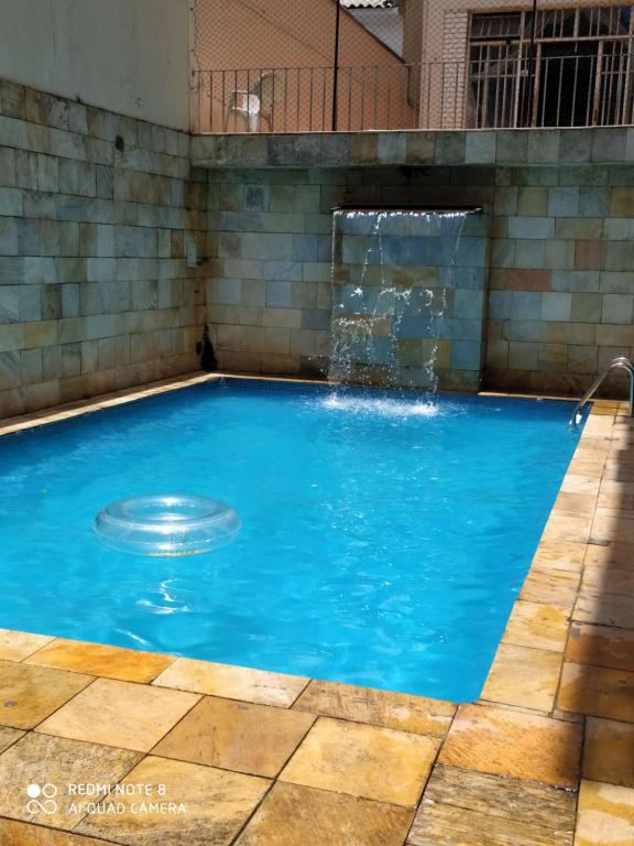 - une piscine d'eau bleue dans un bâtiment dans l'établissement Parada 86 Hostel, à São Paulo