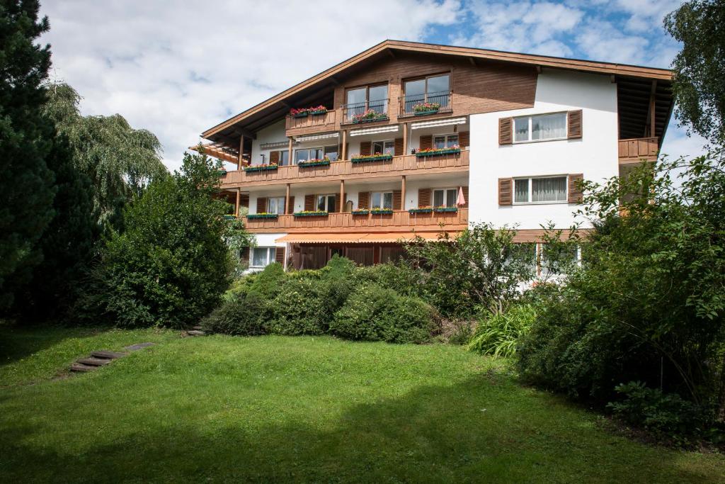ein großes Gebäude mit Rasen davor in der Unterkunft Waldhaus Igls in Innsbruck
