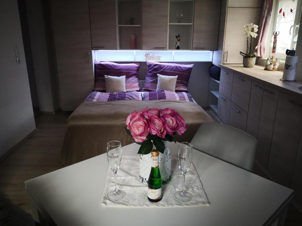una mesa con una botella de vino y flores. en Rheintal Zentrum, en Altach