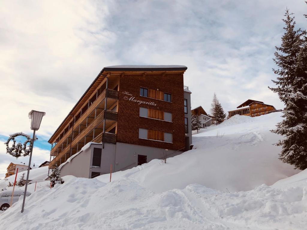 un edificio en la cima de una montaña cubierta de nieve en Haus Margaritta Top 4, en Damüls