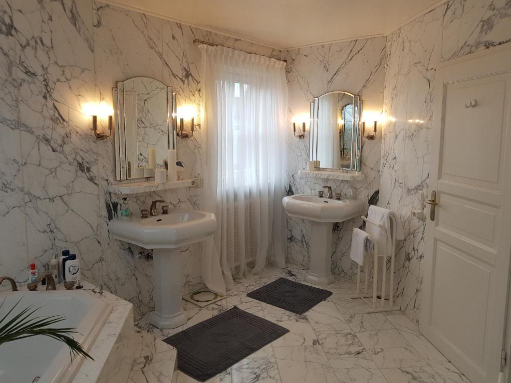 uma casa de banho branca com 2 lavatórios e espelhos em My sweet home em Sauerlach