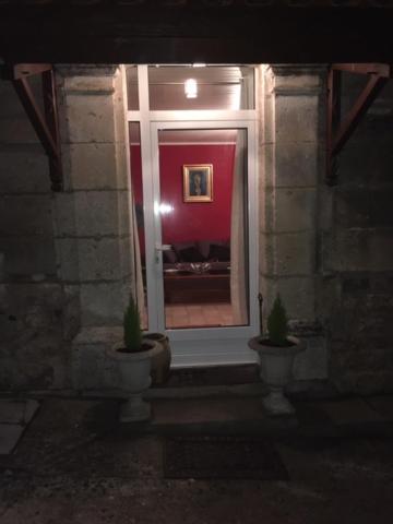 um quarto com duas plantas em frente a uma janela em Le 5 d'Abel em Mornac