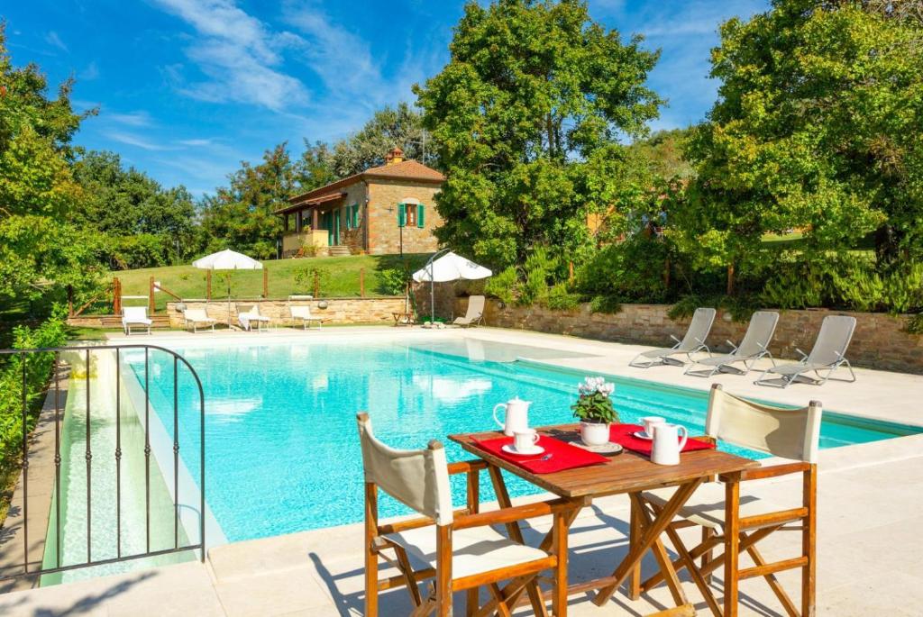 una mesa y sillas junto a una piscina en Villa Casale Federica, en Arezzo