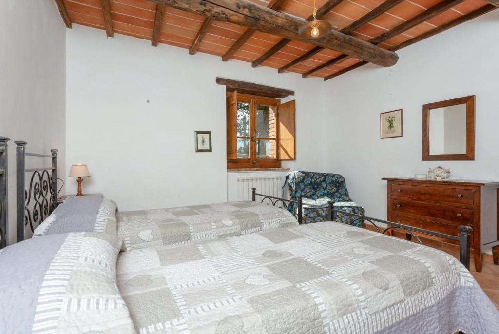 une chambre avec un grand lit et une chaise dans l'établissement Villa Bellavista, à Arezzo