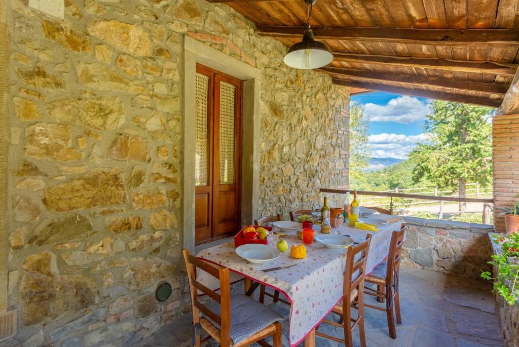 une maison en pierre avec une table et des chaises sur une terrasse dans l'établissement Villa Bellavista, à Arezzo