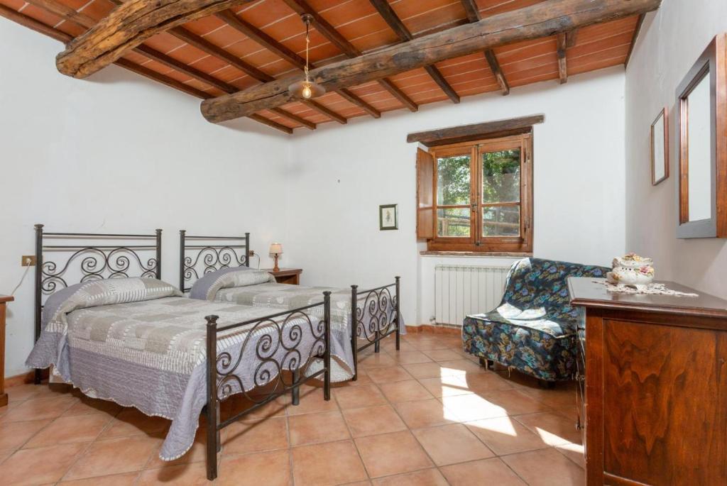 une chambre avec un lit et une chaise dans l'établissement Villa Bellavista, à Arezzo