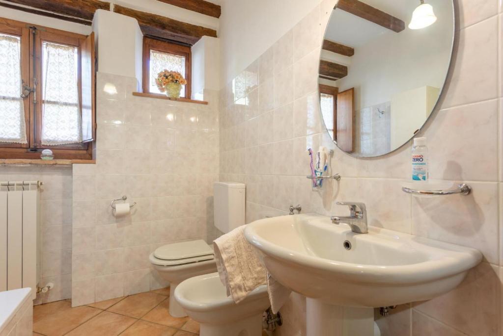 une salle de bain avec un lavabo, des toilettes et un miroir dans l'établissement Villa Bellavista, à Arezzo