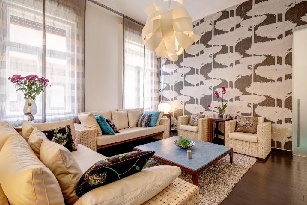 - un salon avec un canapé, des chaises et une table dans l'établissement Luxury Paulay street Apartment, à Budapest