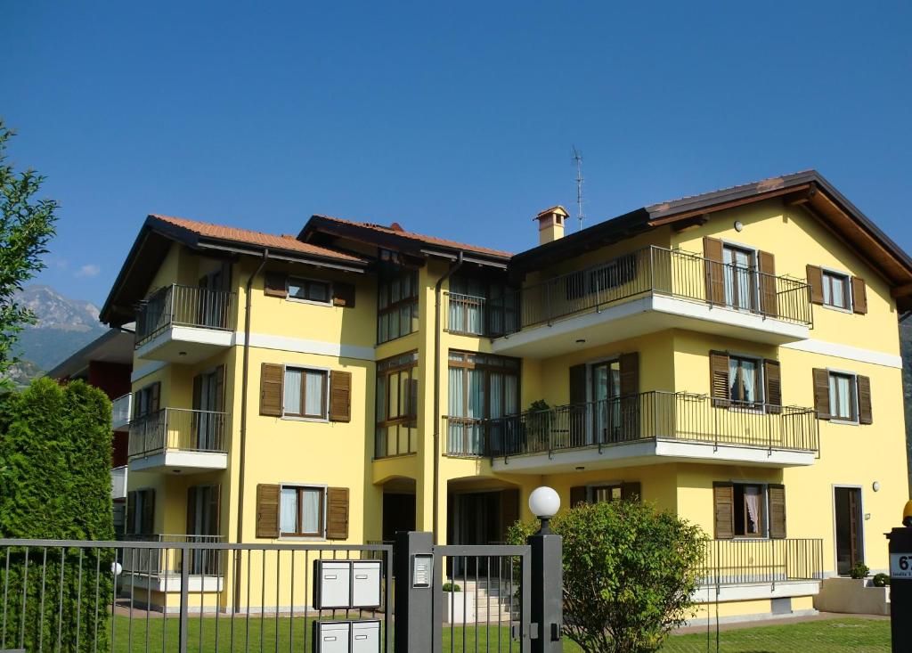 un edificio giallo con una recinzione di fronte di Villa Berta a Riva del Garda